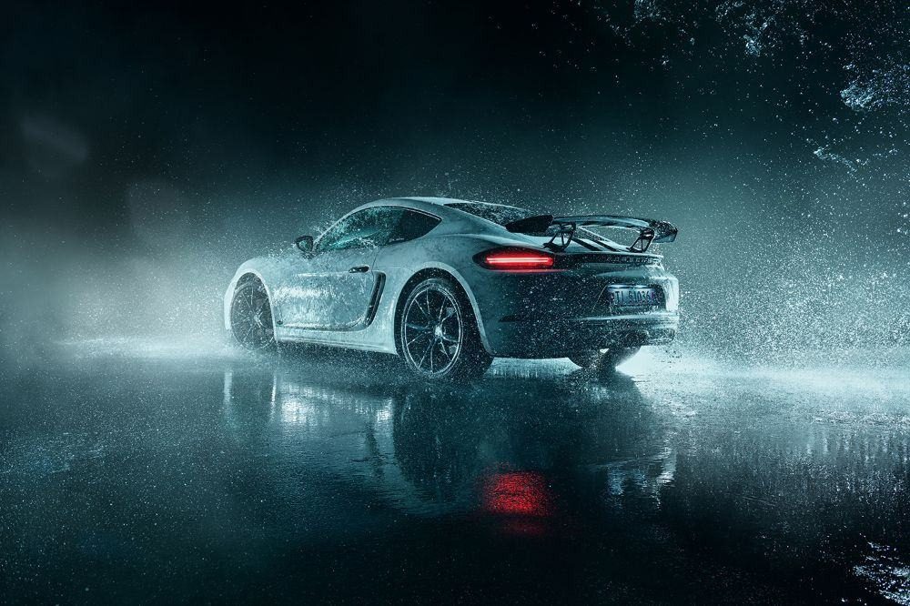 Sports car driving through heavy rain at night